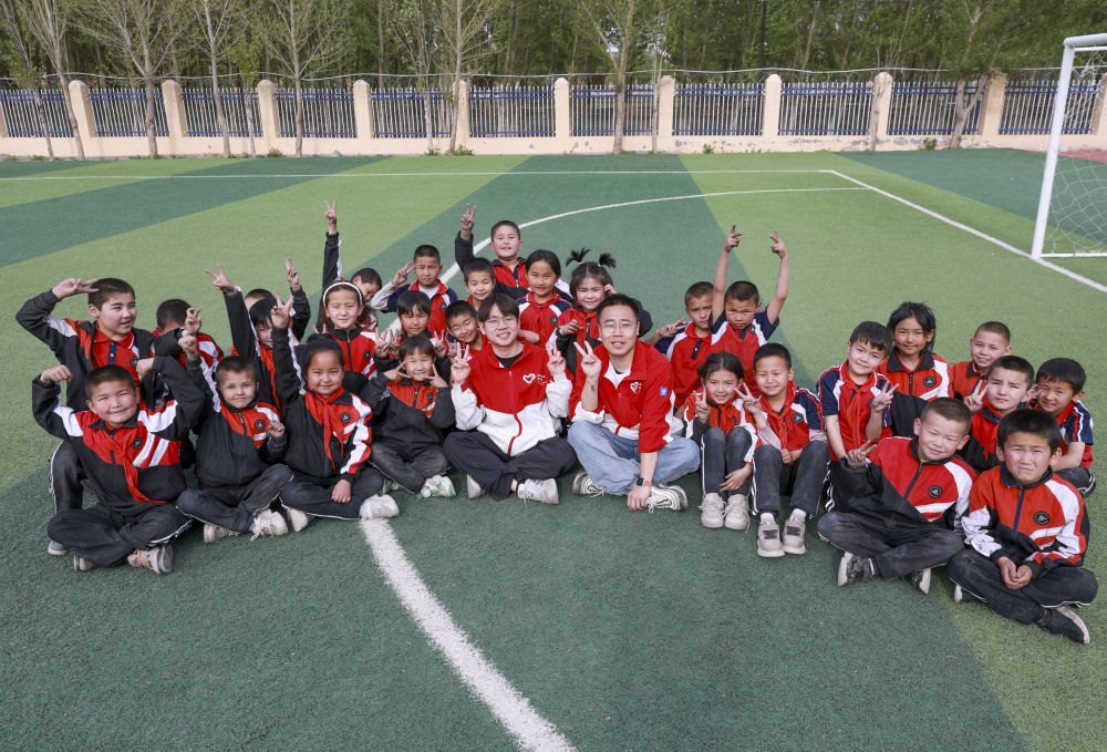 4月23日，在新疆克州阿圖什市哈拉峻鄉(xiāng)謝依特小學(xué)，支教教師王俊文（中左）、李軻凡（中右）和學(xué)生在一起。