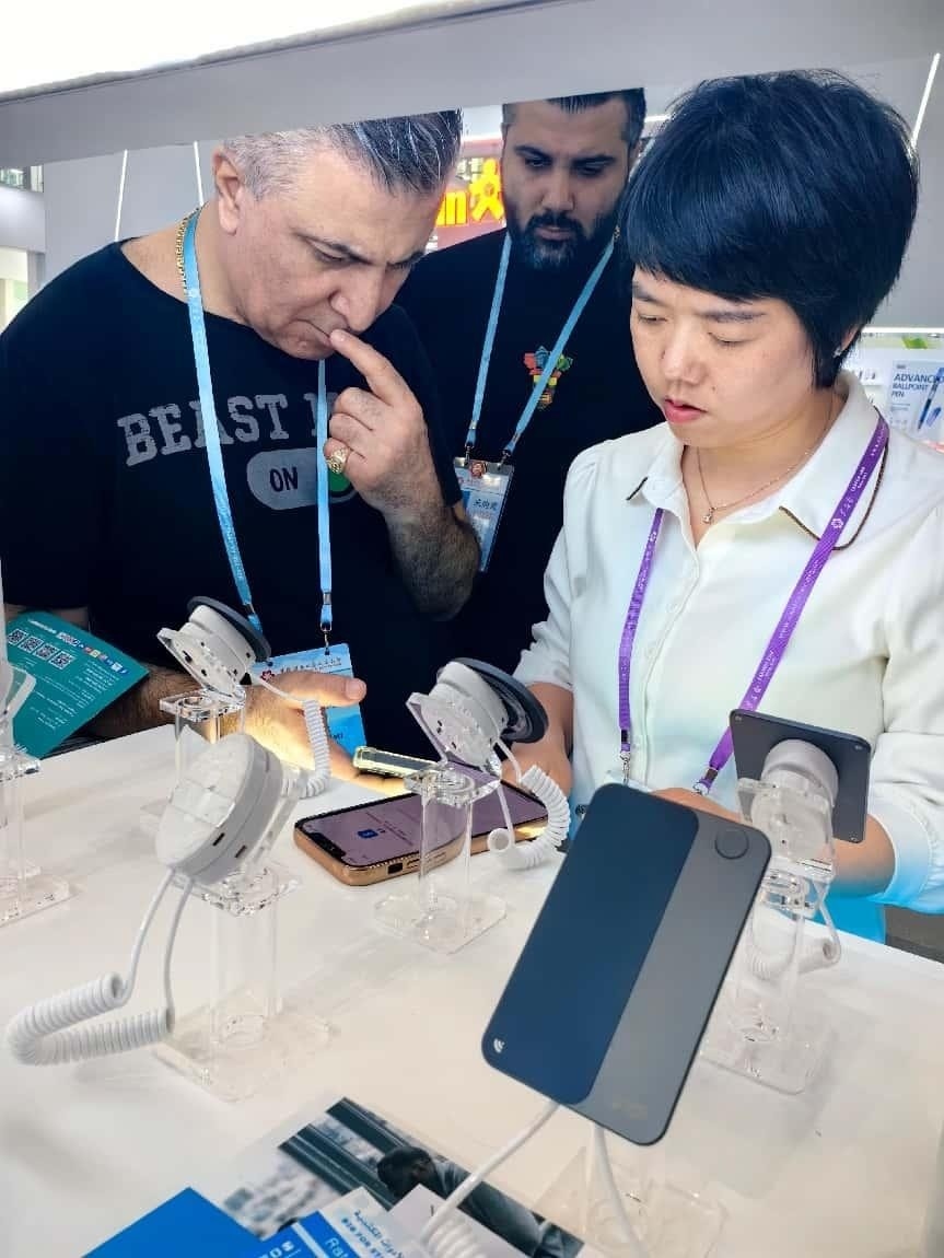 展臺工作人員向外商展示“AI TOP翻譯終端”。圖片來源：受訪者提供