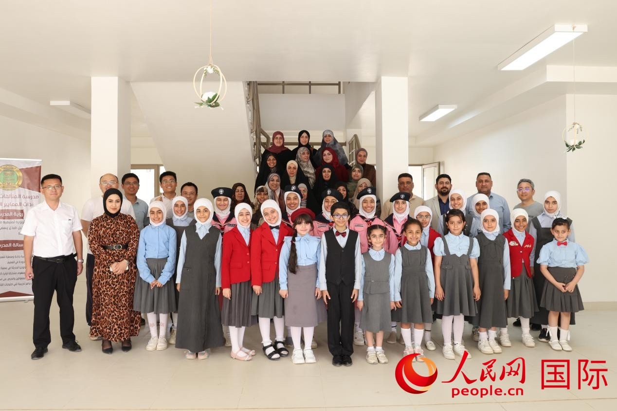 中國電建員工與阿爾穆塔?阿里卡特國際學(xué)校的師生及政府官員等合影。人民網(wǎng)記者 薛丹攝