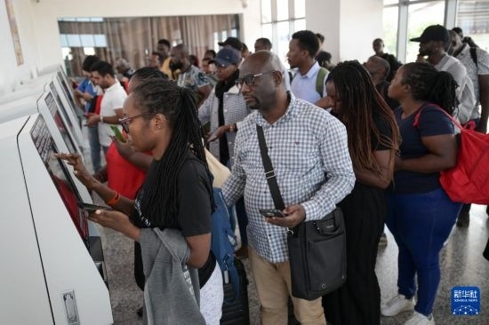 5月31日，在蒙內(nèi)鐵路內(nèi)羅畢站，乘客在自助取票機前排隊取票。新華社記者 楊光 攝