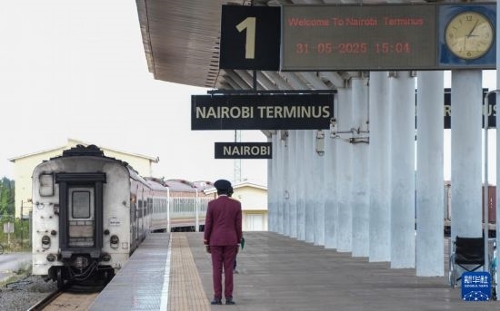 5月31日，在蒙內(nèi)鐵路內(nèi)羅畢站，工作人員目送開往蒙巴薩的E2次列車駛離站臺。新華社記者 李亞輝 攝